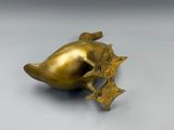 an image of a gold fish shaped object on a white surface