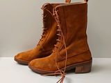 des bottes marron à lacets, posées sur une surface blanche