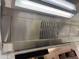 a stainless steel hood in a kitchen with a light above it