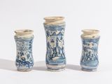 trois vases bleus et blancs posés les uns à côté des autres sur une surface blanche
