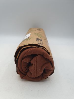 le rouleau de tissu marron est enroulé sur une surface blanche