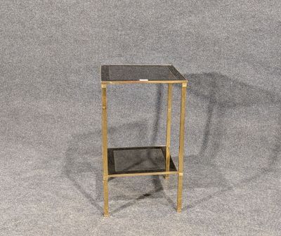 la table d'appoint est dotée d'un plateau en verre et de pieds dorés