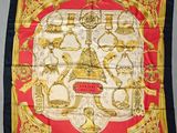 un foulard en soie rouge et or sur lequel sont représentés divers objets