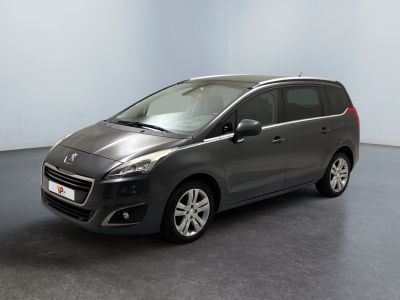 La voiture grise est garée dans une pièce au sol noir.