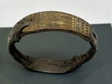 gros plan d'un bracelet en or sur une surface noire