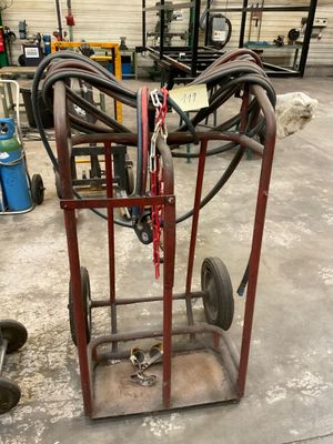 un petit chariot muni d'un tuyau, dans un garage