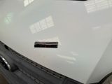 a close up of a white car with a sticker on the hood