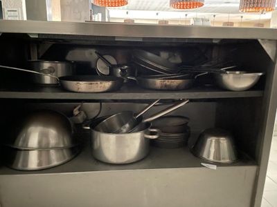 de nombreuses casseroles et poêles sur l'étagère de la cuisine