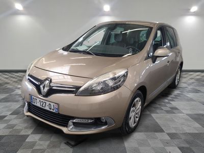 La voiture beige est garée sur le sol à damier de la pièce.