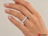 the woman ' s hand is holding a diamond ring with a diamond band
