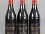 three bottles of red wine sitting on top of a glass table