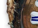 a gold clock with blue and white designs on it