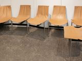 Quatre chaises sont alignées contre un mur dans une pièce.