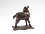 statue of a goat standing on a wooden base against a white background