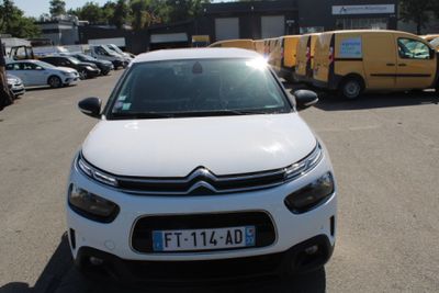 une Citroën blanche garée sur un parking