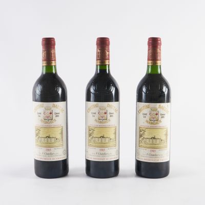 trois bouteilles de vin posées les unes à côté des autres sur une surface blanche