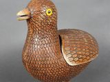 une image représentant un oiseau en bois sur fond gris