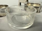 a glass of water sitting on a table next to a bowl of ice