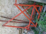 a red scissor sitting on the ground next to a wall
