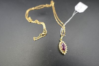 un gros plan d'un collier en or orné d'un rubis