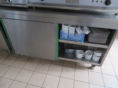 un plan de travail en acier inoxydable sur lequel sont posés des plats, dans une cuisine
