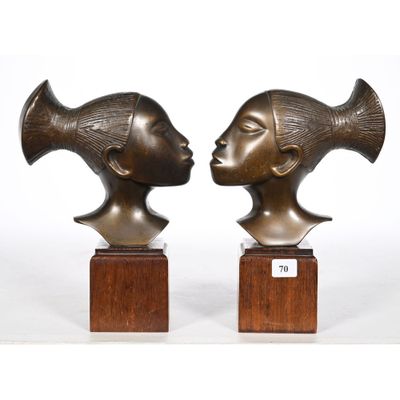 pair of bronze sculptures of a woman ' s head and a man ' s head on wooden bases