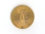 une pièce d'or représentant un ange, sur un fond blanc