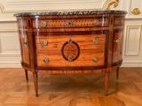 a small wooden cabinet with a marble top on a hard wood floor