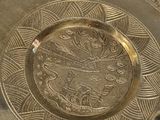 a silver plate that has a design on it