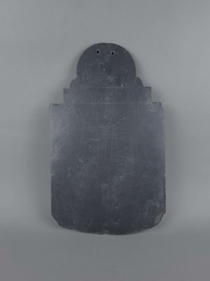 une image représentant une plaque en pierre noire sur laquelle figure un oiseau