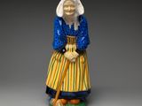 figurine of an old woman with a cane and a hat