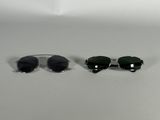 two pairs of sunglasses sitting next to each other on a white surface
