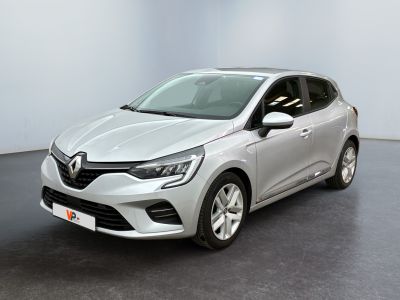 Une voiture argentée est garée dans une pièce au sol noir.