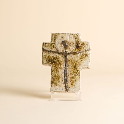 une croix sur laquelle est représenté un homme, posée sur une table