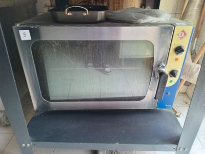 a small oven sitting on top of a shelf in a room