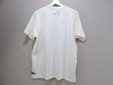 the white shirt is hanging on a hanger on the wall