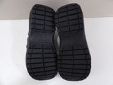 pair of black slippers on a white surface with a white background