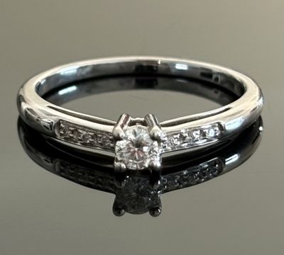 a close up of a diamond ring on a black surface