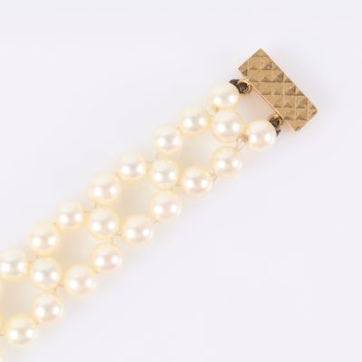 un gros plan sur un bracelet en perles muni d'un fermoir en or