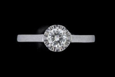 gros plan d'une bague en diamant sur fond noir