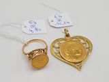 Deux pièces d'or et une bague en or sont posées sur une table blanche