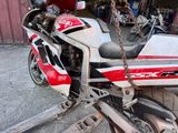a red and white motorcycle parked in front of a garage