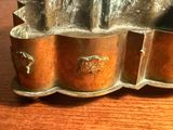 un moule à gâteau en argent contenant un gâteau, posé sur une table en bois