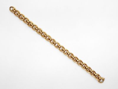 gros plan d'un bracelet en chaîne en or sur fond blanc
