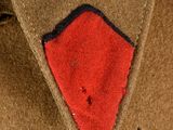 a close up of a brown jacket with a red patch