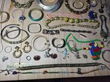 many different types of bracelets and necklaces on a table
