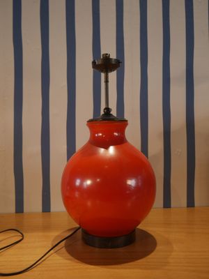 une lampe rouge posée sur une table en bois