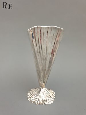 un vase en argent posé sur une table