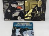 two books on a white surface one is a man with a gun and the other is a woman with a gun