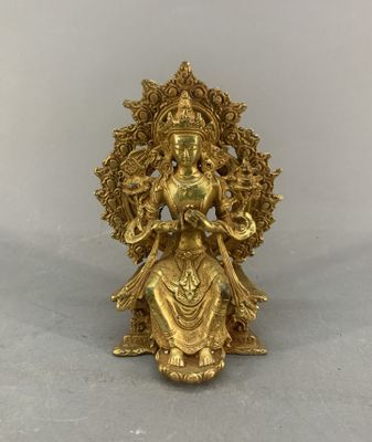 a gold statue of a woman sitting on top of a table